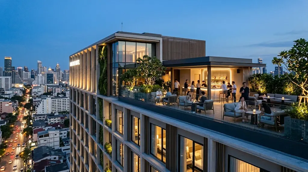 Modern lifestyle hotel with rooftop lounge and illuminated city skyline at dusk